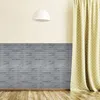 Graue Holzvertäfelung an einer Wand, darüber eine hellgelbe Wand und darunter ein Holzboden, neben einem gemusterten gelben Vorhang Náhled obrázku produktu
