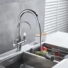A modern kitchen sink area with a chrome faucet and a sink insert containing fruit. Náhled obrázku produktu