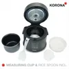 A rice cooker and its accessories are displayed on a white background. The rice cooker lid is open, revealing the inside. Several accessories, including a measuring cup, rice spoon, and steamer basket, are arranged around the cooker. Anteprima dell’immagine prodotto