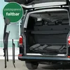 A camping chair is shown folded and placed inside the trunk of a car, next to another folded chair. The trunk is open, revealing the interior of the vehicle. Produktbild-Vorschau