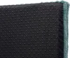 Close-up view of the underside of a cushion or mat, showing a black fabric with numerous small, raised, dark grey dots, and a teal fabric border along the right edge. Produktbild-Vorschau