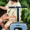 A child sitting with a scooter in a garden. Produktbild-Vorschau
