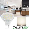 A modern kitchen and dining area with a focus on lighting, featuring a close-up of an LED bulb and a sample of its light output. Produktbild-Vorschau