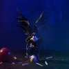 A dark, moody scene with a winged creature and an apple. Voir les images du produit