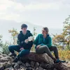 Zwei Personen in Outdoor-Bekleidung sitzen auf einem Felsen und halten den "Climbing Mug" von YY Vertical. Podgląd zdjęcia produktu