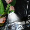 A person is using a green flashlight to inspect the engine of a car in the dark. Produktbild-Vorschau