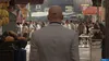 A man in a suit walks through a bustling marketplace. Produktbild-Vorschau