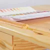 A close-up view of a wooden desk with a watercolor paint set on it. Produktbild-Vorschau