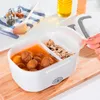A person's hand is closing the lid of a white electric lunchbox filled with food, placed on a wooden cutting board. Anteprima dell’immagine prodotto