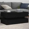 A black coffee table with a modern design, placed in a living room setting with a sofa and cushions. Náhled obrázku produktu