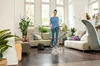 A woman is using a steam cleaner in a living room. Podgląd zdjęcia produktu