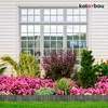A garden border made of wood, with flowers and plants in front of a house window. Náhled obrázku produktu