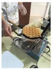 A person is using a bubble waffle maker to cook a waffle. Podgląd zdjęcia produktu