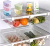 A refrigerator shelf with various food items stored in clear plastic containers and drawers. Produktbild-Vorschau