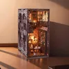 A miniature, illuminated DIY book nook kit designed to look like a castle interior, placed on a wooden surface. Voir les images du produit