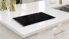 A black glass stovetop cover is placed on a white quartz kitchen countertop. Anteprima dell’immagine prodotto
