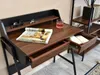 A minimalist desk with a magazine, a glass of drink, and an open drawer. Náhled obrázku produktu