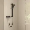A black shower faucet and showerhead mounted on a tiled wall. Anteprima dell’immagine prodotto