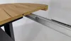 A close-up view of a wooden table's extension mechanism, showing the wooden tabletop and the metal sliding rails. Náhled obrázku produktu