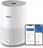 A white Philips air purifier is shown alongside two smartphones displaying the Philips Air app. Podgląd zdjęcia produktu
