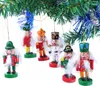 A group of wooden nutcracker ornaments hanging from a Christmas tree branch. Voir les images du produit