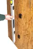 A hand is holding a spirit level against a wooden wall with connectors attached. Produktbild-Vorschau
