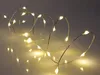 A string of warm white LED lights on a thin wire, coiled and spread out on a reflective surface. Náhled obrázku produktu