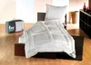 A white duvet and pillow are laid out on a bed, with a storage bag to the left. Produktbild-Vorschau