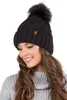 A woman wearing a black knitted beanie with a faux fur pom-pom. Náhled obrázku produktu