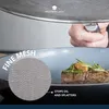 A hand holding a splatter screen over a frying pan with food. Produktbild-Vorschau