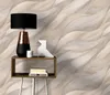 A table with a lamp, a candle, a decorative object, and books, placed against a textured wall. Podgląd zdjęcia produktu