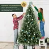 A man and a woman are decorating a Christmas tree with ornaments and presents underneath. Produktbild-Vorschau