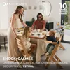 A family is gathered around a dining table, with children and a baby in high chairs. The scene depicts a mealtime setting. Voir les images du produit