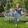 A woman and a child are sitting in a hanging chair in a garden. Náhľad obrázku produktu