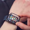 A person's hand is applying a screen protector to an Apple Watch. Náhľad obrázku produktu