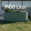 A raised garden bed filled with plants sits on a lawn in front of a modern house. Produktbild-Vorschau