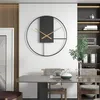 A modern dining room with a large wall clock, dining table, and chairs. Produktbild-Vorschau