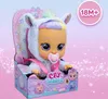 A Cry Babies Dressy Jenna doll is displayed in its packaging, which features a pink and white background with glittery accents. Voir les images du produit