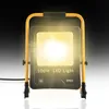 A bright LED work light is shown on a reflective surface with a dark gradient background. Produktbild-Vorschau