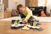 A young boy is playing with a dinosaur-themed toy set on the floor in a living room. Anteprima dell’immagine prodotto