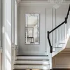 A well-lit hallway with a staircase and a decorative mirror. Produktbild-Vorschau