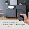 A hand holding a smartphone is shown in the foreground, with a stereo system on a dresser in the background. Text overlays describe the product's features. Produktbild-Vorschau