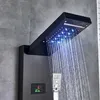 A close-up of a modern black shower panel with water flowing from the LED-lit rain showerhead. Náhľad obrázku produktu