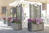 Outdoor cafe seating area with planters and umbrellas. Anteprima dell’immagine prodotto