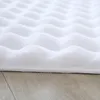 A close-up view of a white, fluffy rug with a wave-like texture, resting on a wooden floor. Produktbild-Vorschau