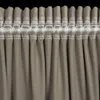 A close-up view of the top edge of a curtain with pleats and a hanging tape. Podgląd zdjęcia produktu