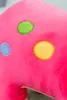 A close-up of a pink plush toy with colorful polka dots. Voir les images du produit