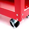 A close-up view of the corner of a red tool cart, showing the wheels and metal construction. Produktbild-Vorschau