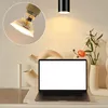 A close-up of a light bulb and a laptop on a shelf, with decorative vases and a flower arrangement. Produktbild-Vorschau