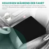 A black seat cushion placed on a car seat, with text overlays describing its benefits. Produktbild-Vorschau